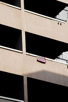 A minimalist building facade displaying balconies with dramatic shadows.