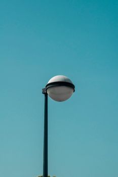 A minimalist streetlight set against a clear blue sky, symbolizing simplicity and modern design.