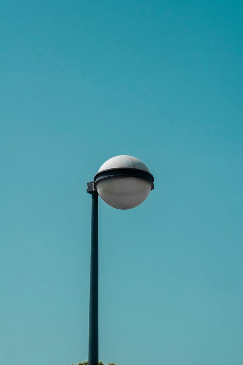 Free A minimalist streetlight set against a clear blue sky, symbolizing simplicity and modern design. Stock Photo