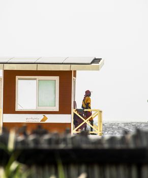 Construction worker standing near a building in Dubai with skyline backdrop.