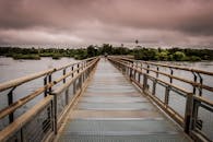 一座风景优美的大桥横跨河上，天空阴沉，捕捉到了自然与冒险的精髓