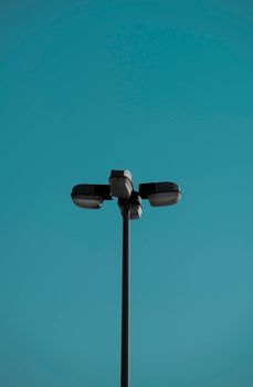Modern street lamp against a vibrant blue sky, showcasing minimalist design.