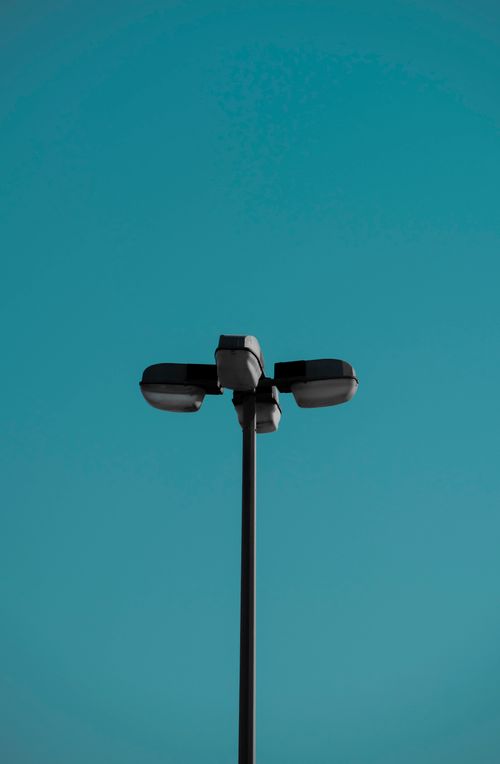 Free Modern street lamp against a vibrant blue sky, showcasing minimalist design. Stock Photo