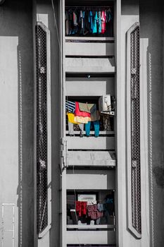 A close-up view of an apartment building facade with vibrant laundry hanging outside.