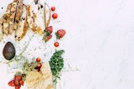 大理石上摆放着新鲜食材，有面包、草莓和鳄梨，勾勒出完美的食物与生活方式图景