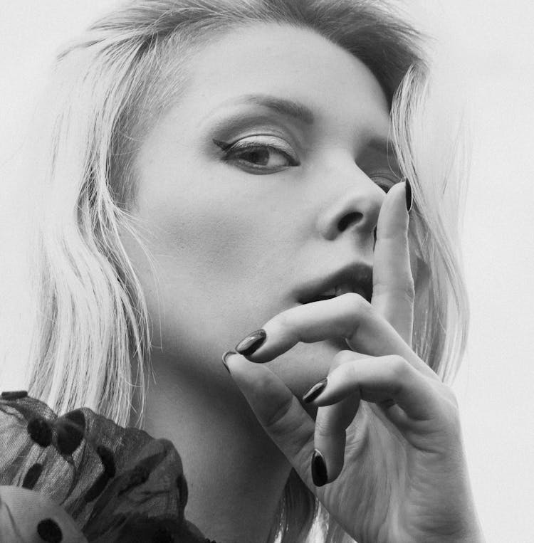 Woman Posing With Hand Over Mouth In Black And White