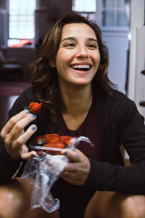 Woman Eating Strawberry Indoors