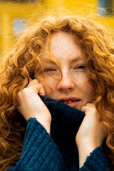 Close-up portrait of a freckled redhead woman in Kyiv, showcasing vibrant natural beauty and urban style.