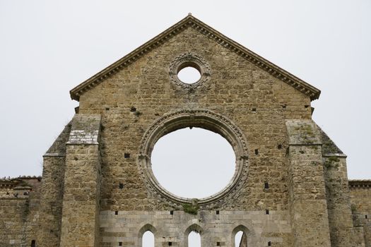 Gothic architecture of the Abbey of San Galgano ruins, showcasing historical stone facade.