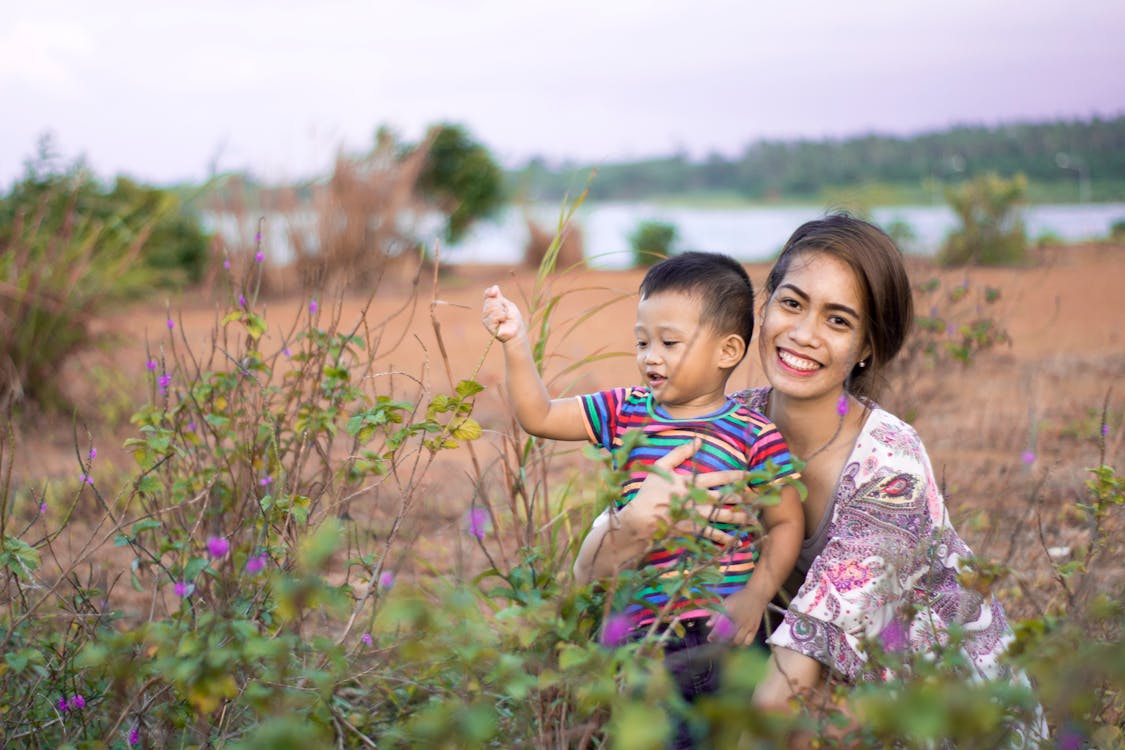 Free Woman Hugging Boy on Field Stock Photo