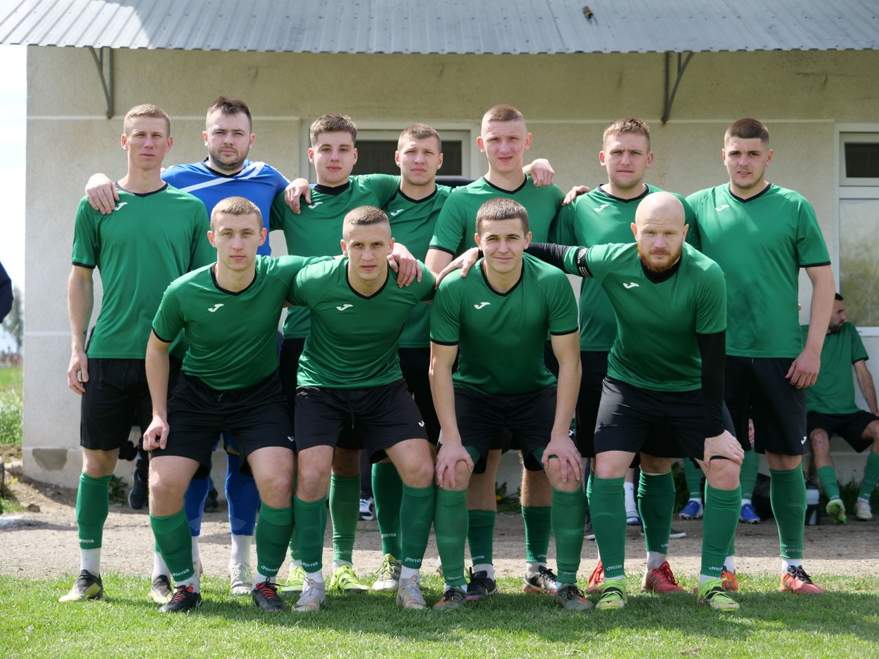 a group of amateur soccer players posing together in sportswear outdoo