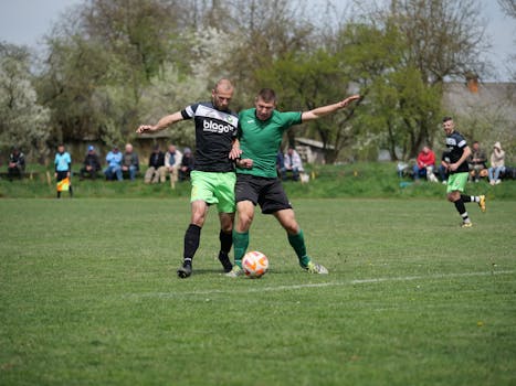 Two male soccer players in action during an outdoor match, showcasing competitive play.