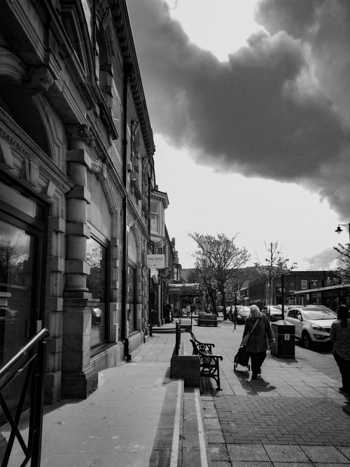 Free Urban street scene in black and white featuring neoclassical architecture with dramatic clouds overhead. Stock Photo