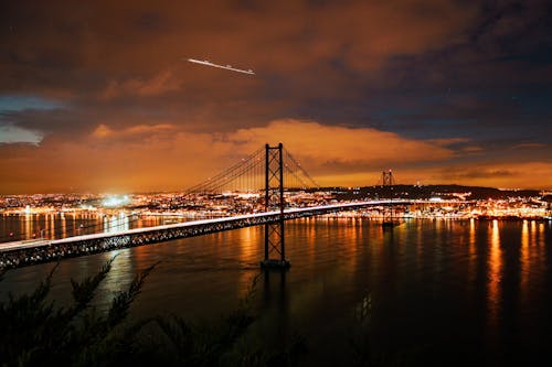 25 nisan köprüsü, aydınlatılmış, deniz kenarı içeren Ücretsiz stok fotoğraf