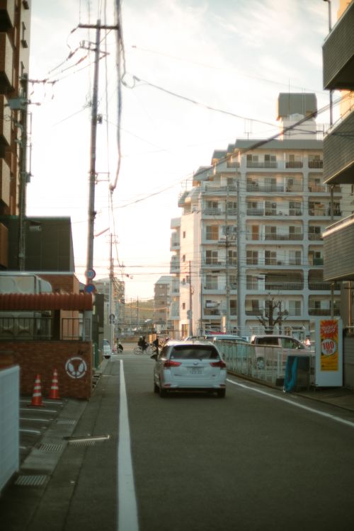Free Charming street view with modern buildings and a car in a serene urban setting. Stock Photo