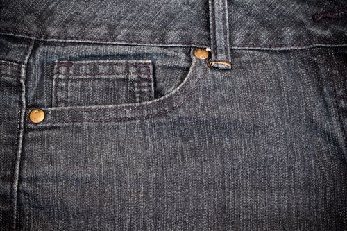 Free Detailed view of blue denim jeans showcasing stitching and copper rivets. Stock Photo