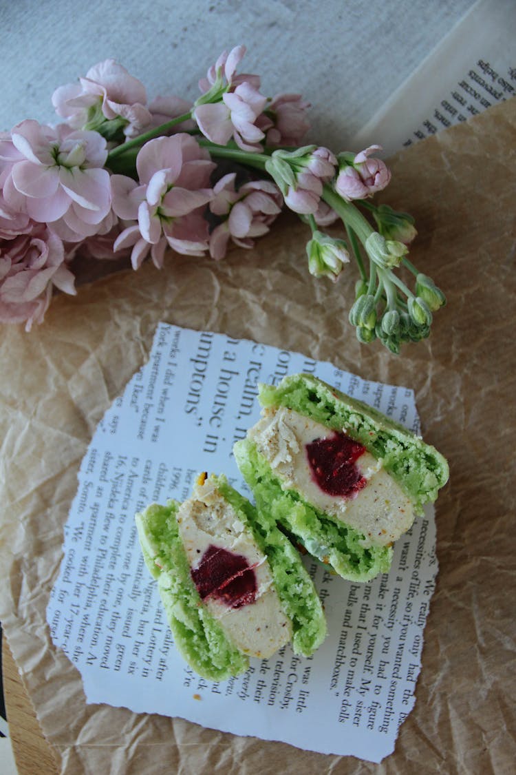 Green Macaron Cut In Half With Jelly Inside The Filling