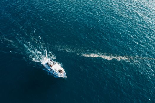 High angle aerial view of a motorboat creating a wake in the open ocean.