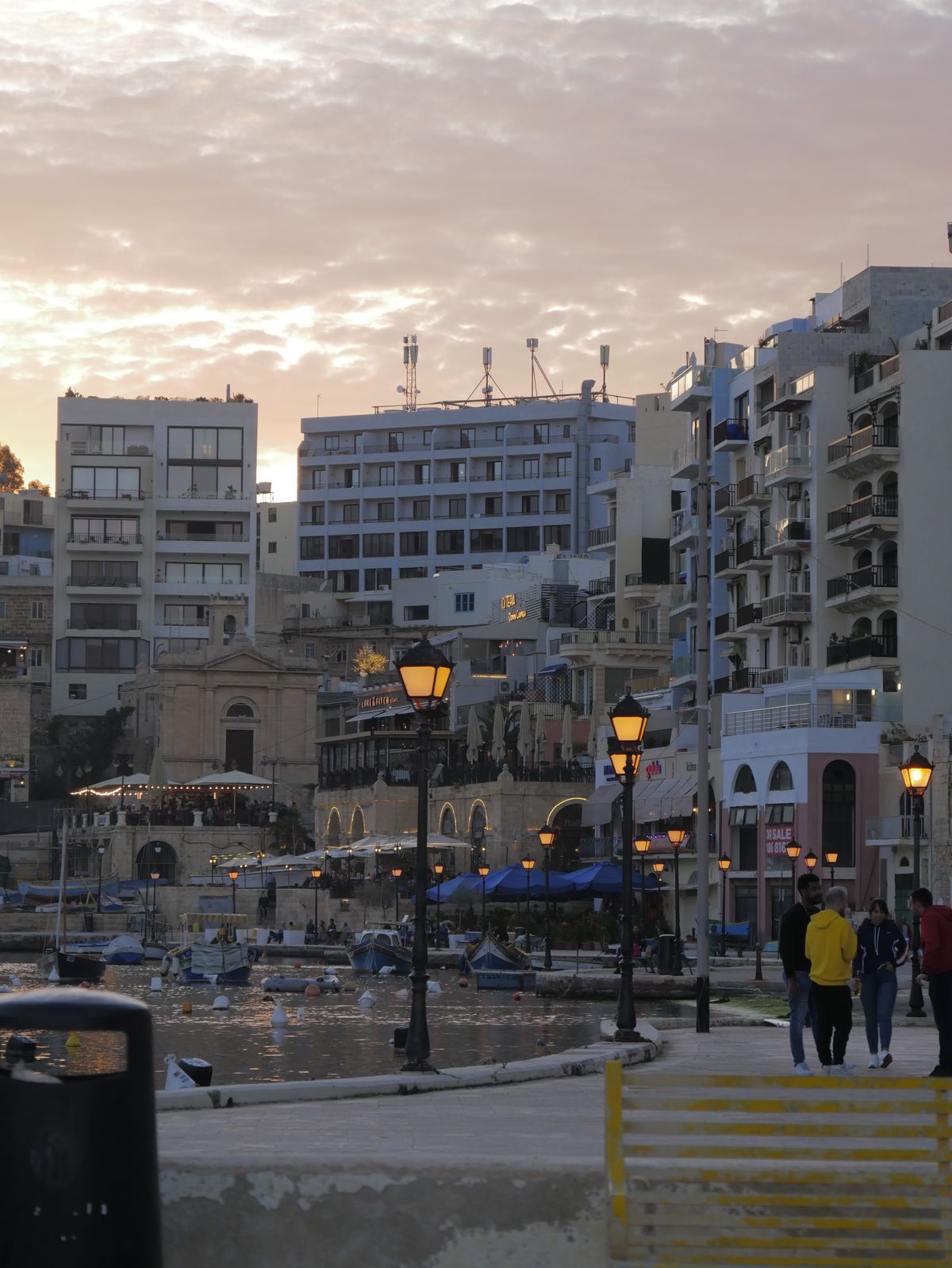 St Julian's Malta - faleza și bărcile la apus, cu clădirile pe promenadă