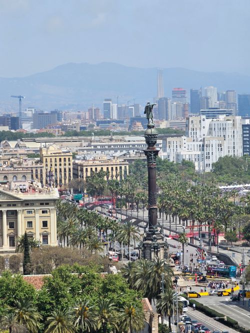 Free Aerial view of Columbus Monument surrounded by iconic cityscape and palm trees in Barcelona. Stock Photo