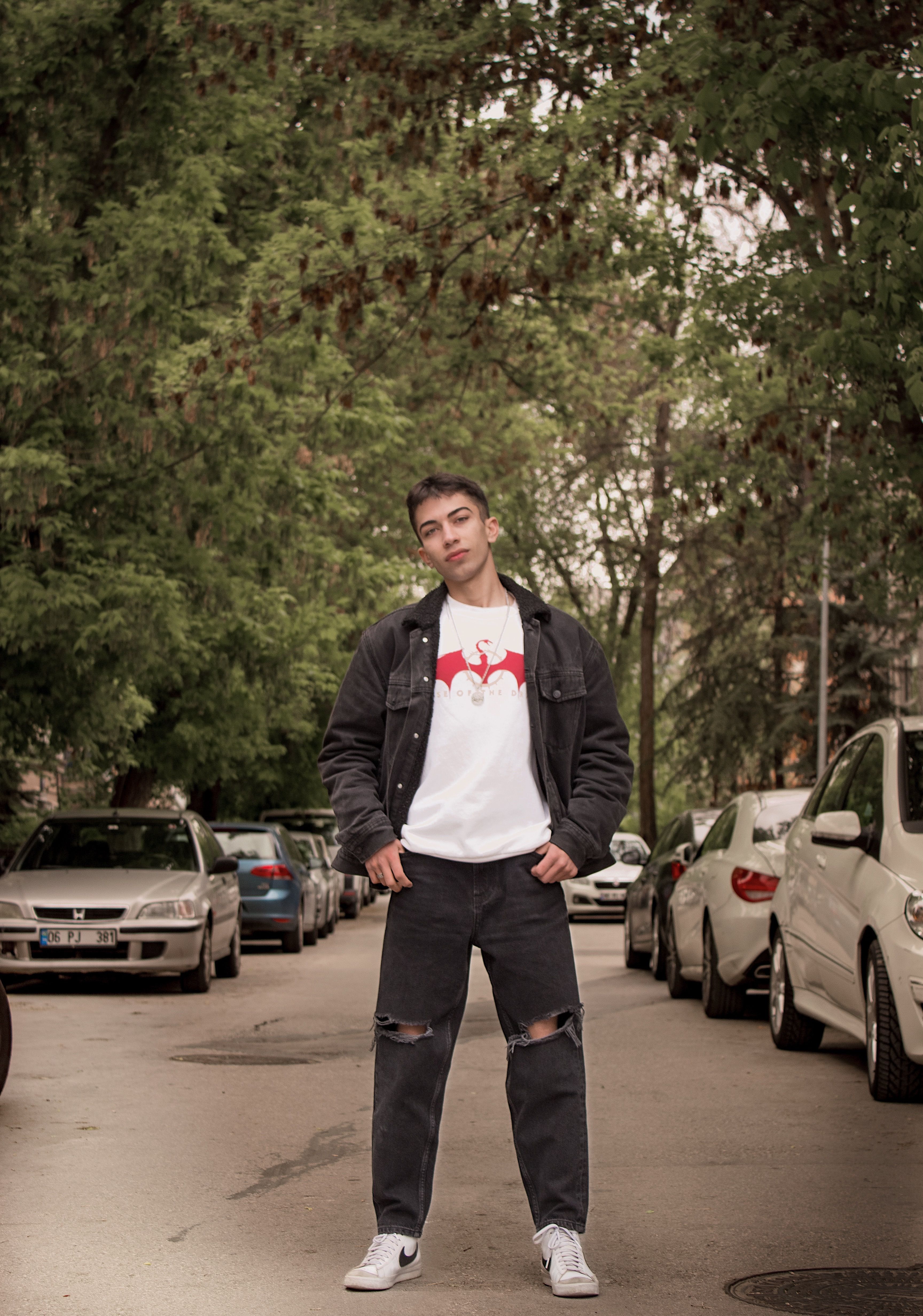 Young man posing confidently in urban street setting in Ankara, Türkiye.