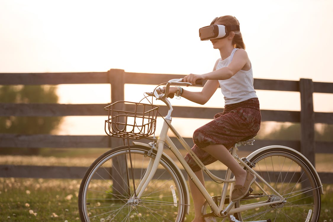 Menina andando de bike no Metaverso, com óculos de realidade aumentada 