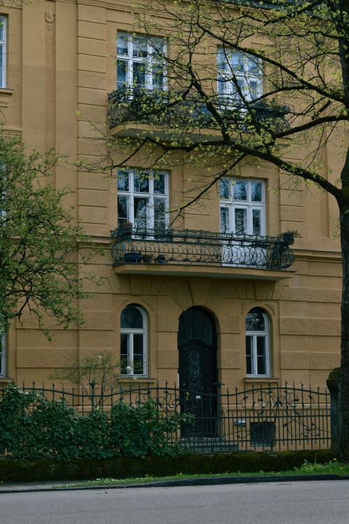 Free Charming urban scene featuring a vintage residential building with balconies and trees. Stock Photo