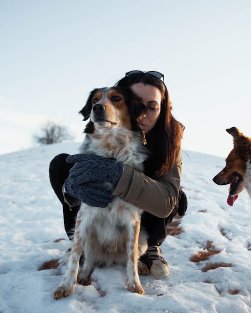 Woman Hugging Dog in Snow