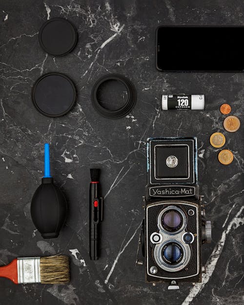 Flat Lay of Vintage Camera Equipment Coins and Paintbrush