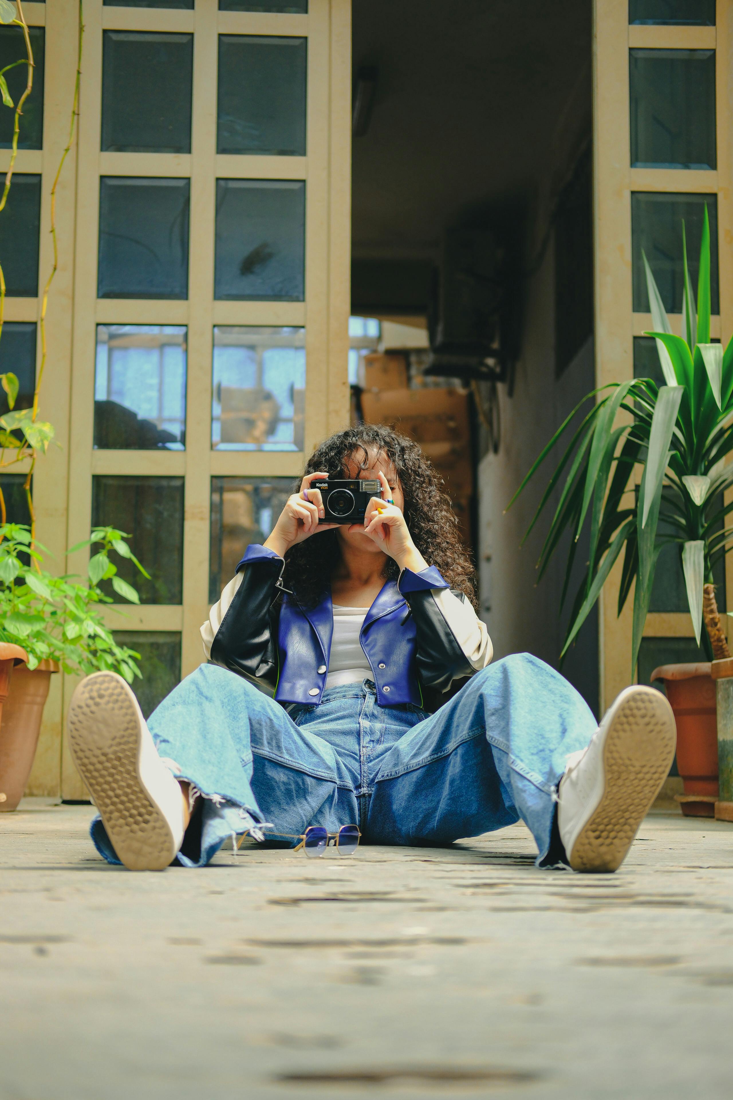 a woman sitting on the ground with her camera