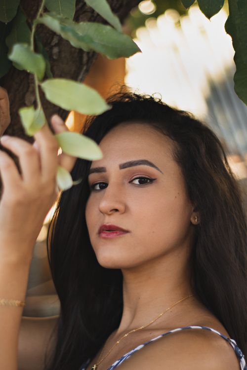 Free Close-up portrait of a woman with leaves, emphasizing natural beauty and elegance. Stock Photo