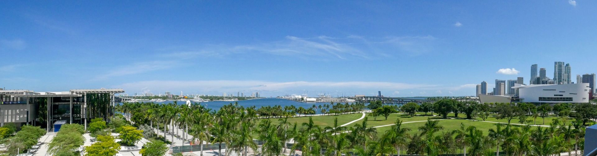 Palm-lined Museum Park and Biscayne Bay with the downtown Miami skyline and Kaseya Center in the distance