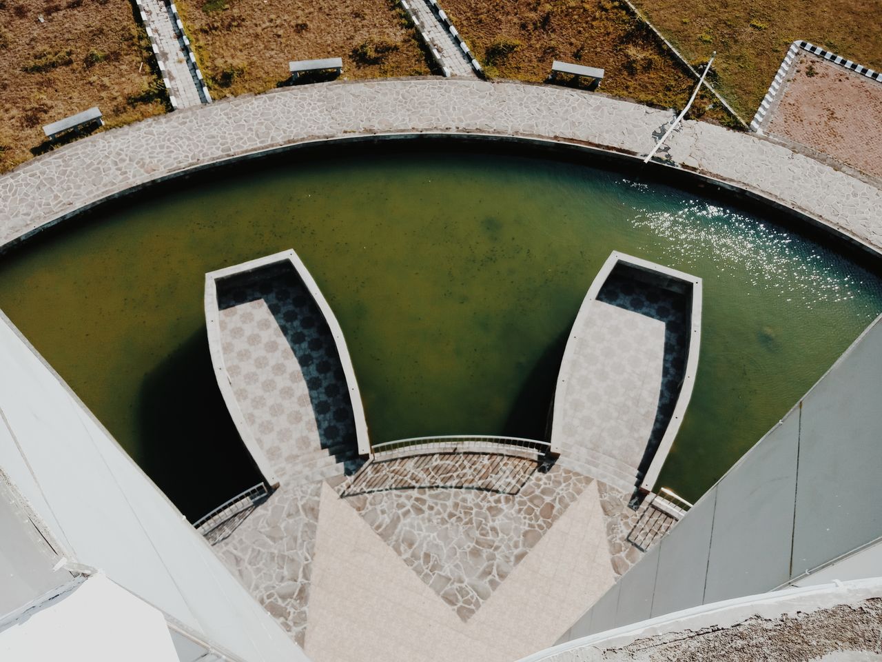 aerial view of a circular water feature surrounded by stone pathways i
