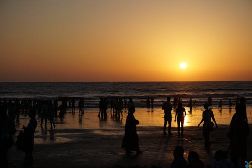 人們在日落時在海灘上的剪影