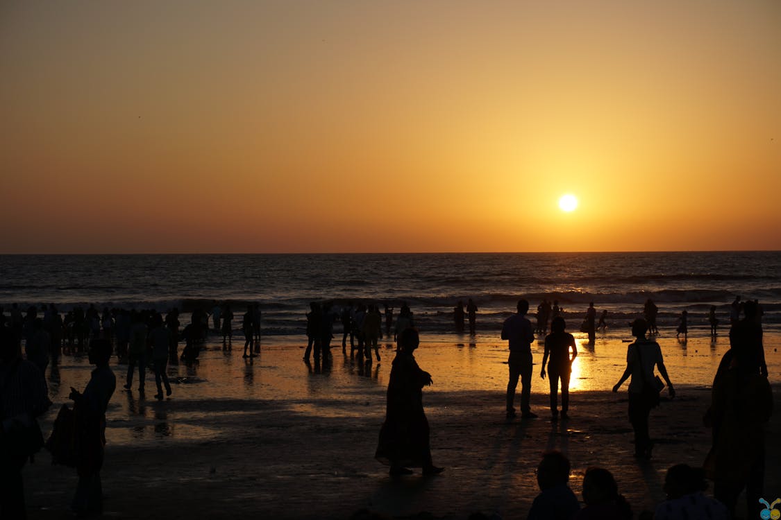gratis Silhouetten Van Mensen Op Het Strand Bij Zonsondergang Stockfoto