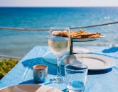 阳光明媚的日子里，优雅的海滨用餐场景供应着葡萄酒、咖啡和糕点