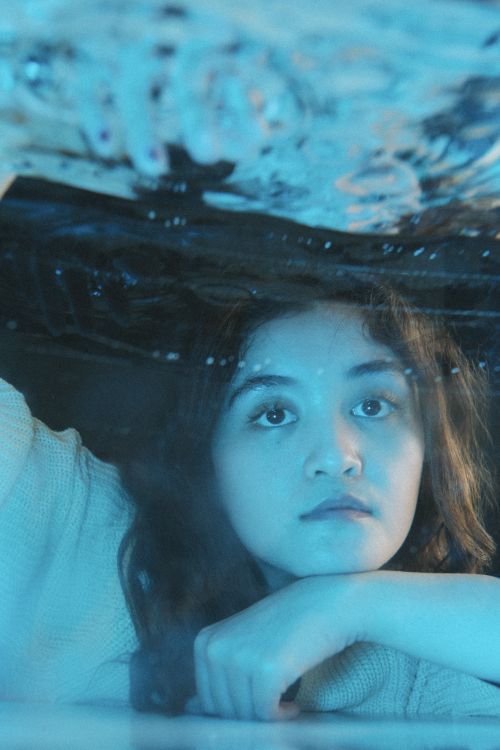 Free A captivating portrait of a woman depicted through water with a serene expression. Stock Photo