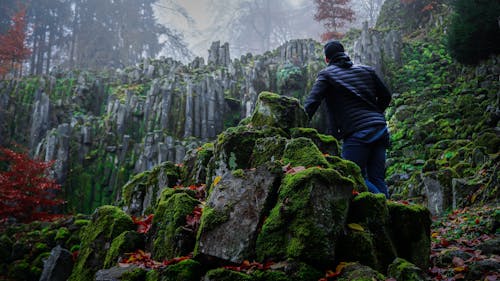 Person Standing in Front of Rock Formation