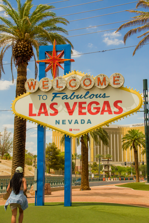 Free Famous Las Vegas sign with palm trees and vibrant city backdrop. Stock Photo