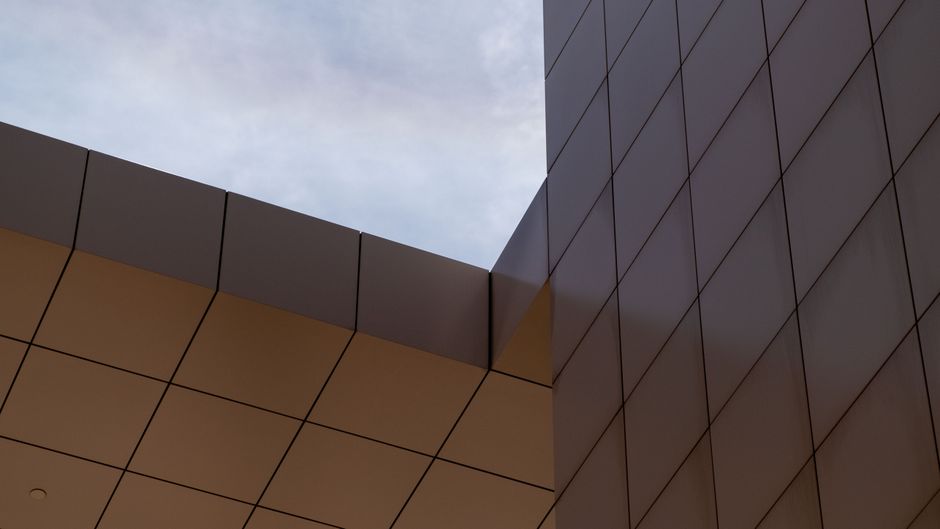 Modern architectural structure with geometric patterns under an open sky.