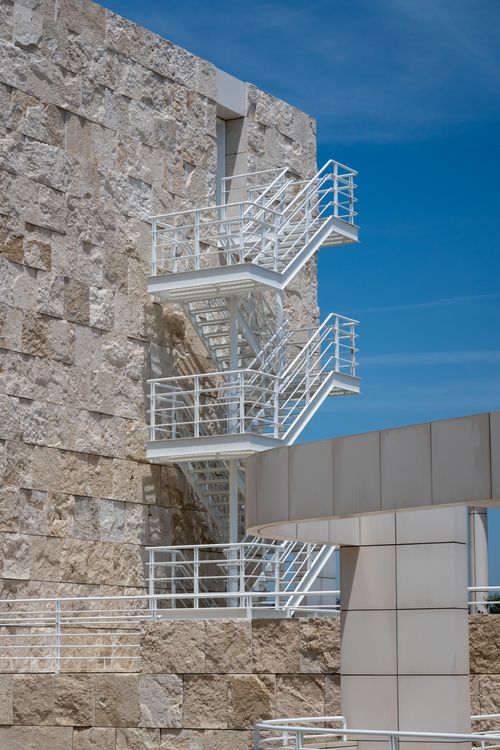 Free White metal fire escape on a modern stone building against a clear blue sky. Stock Photo
