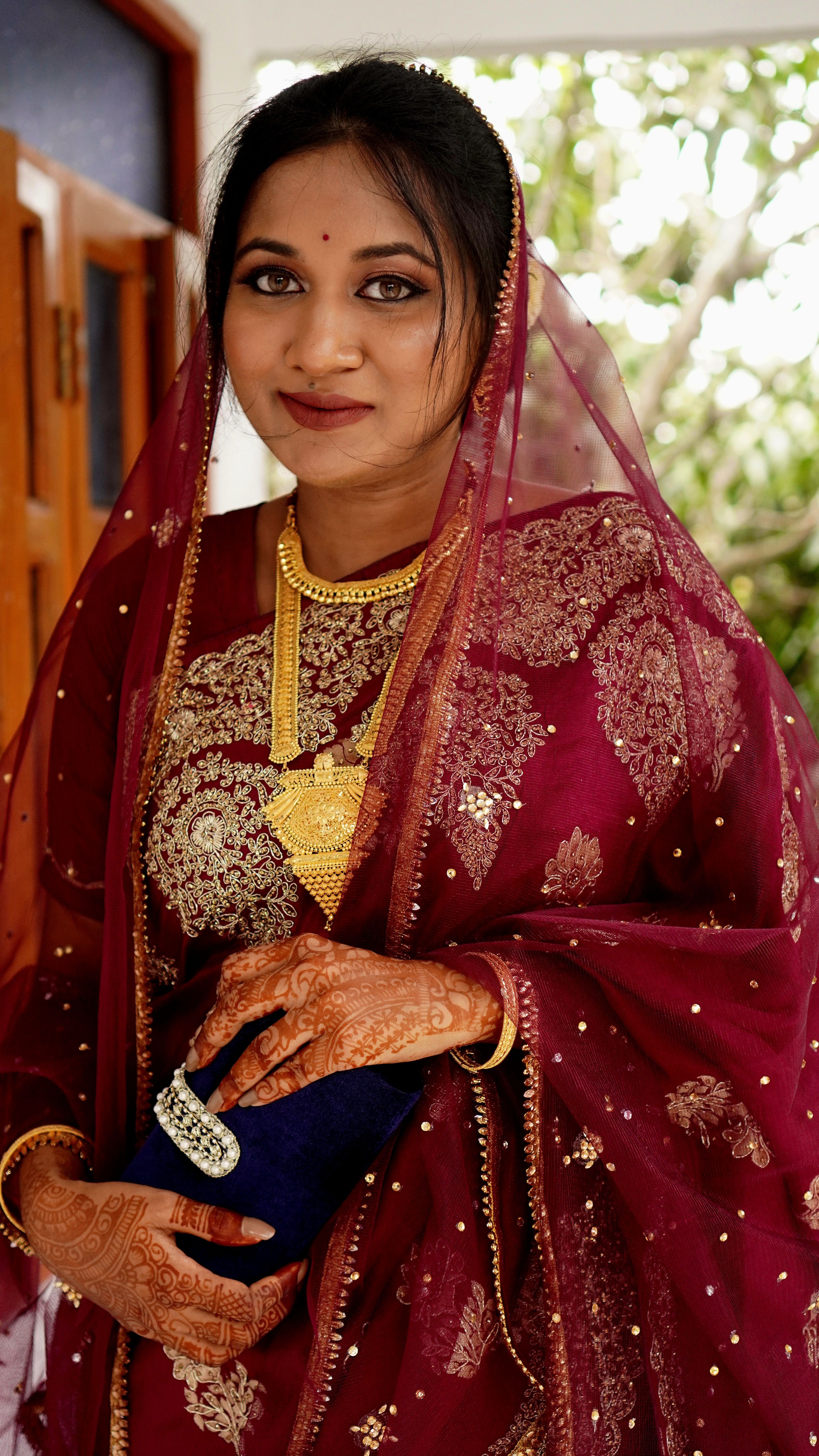 Stunning portrait of an Indian bride in a red lehenga adorned with henna tattoos, showcasing cultural elegance.