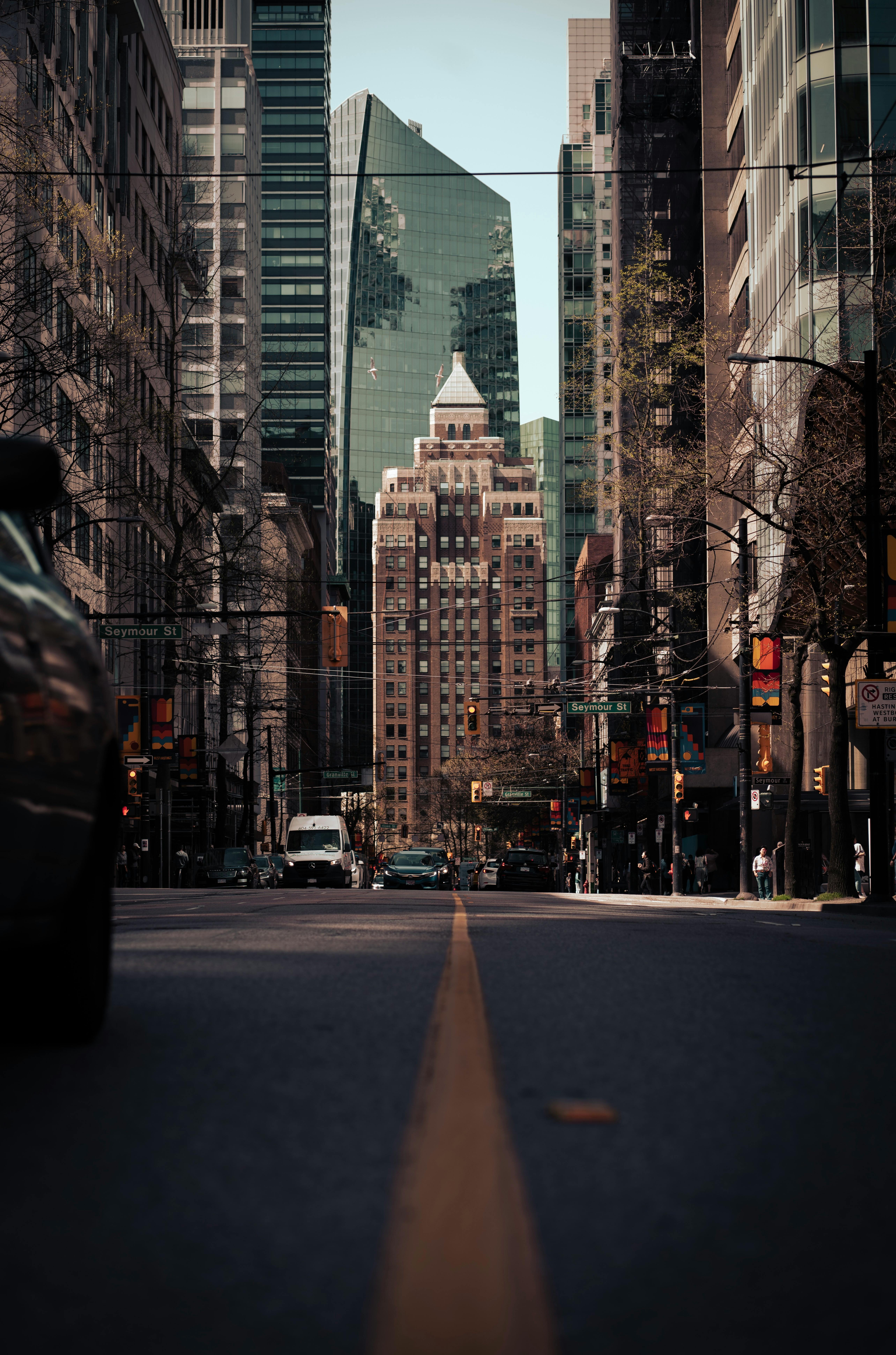 A vibrant view of downtown Vancouver with modern skyscrapers lining a busy street.