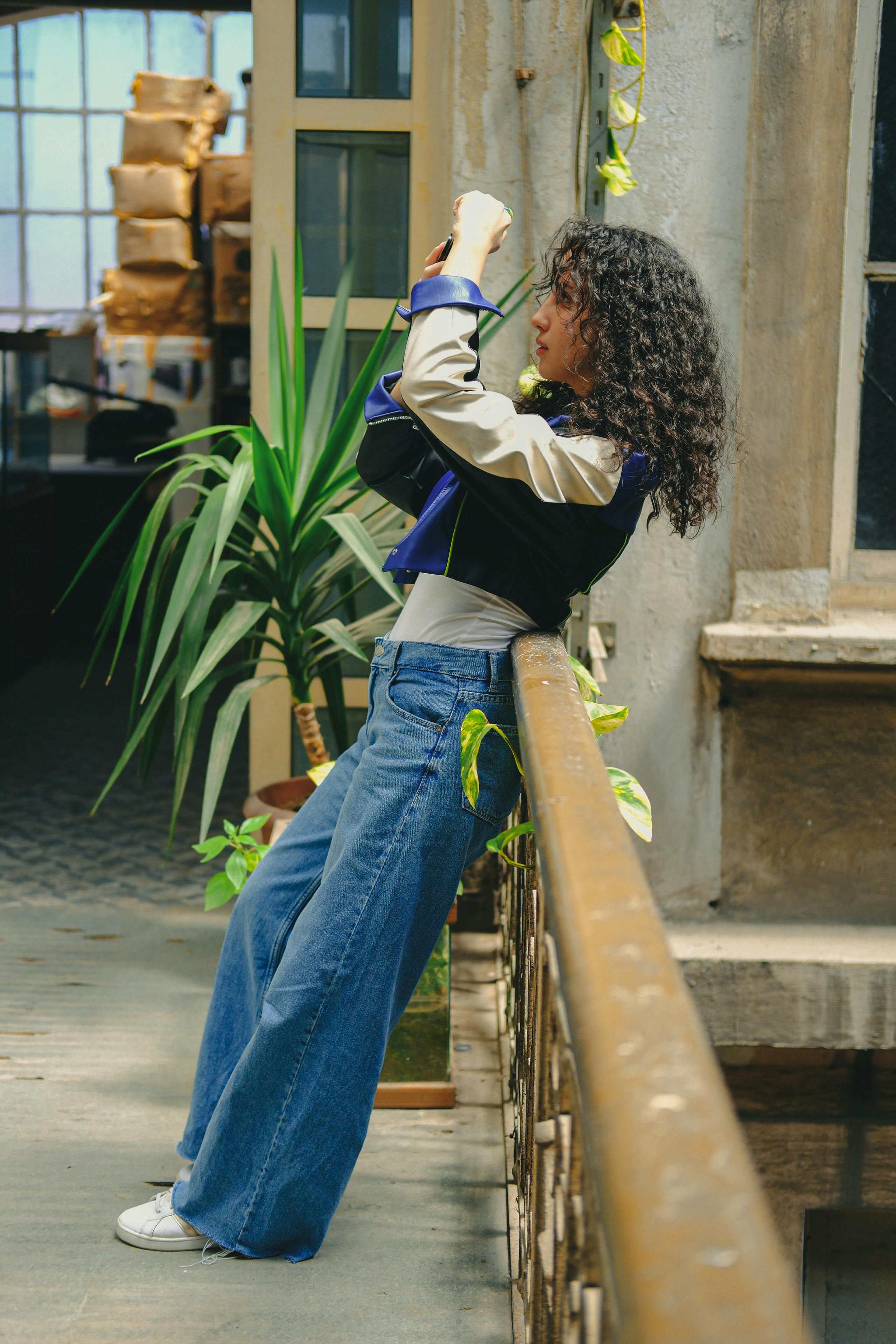 a woman in jeans and a jacket taking a picture