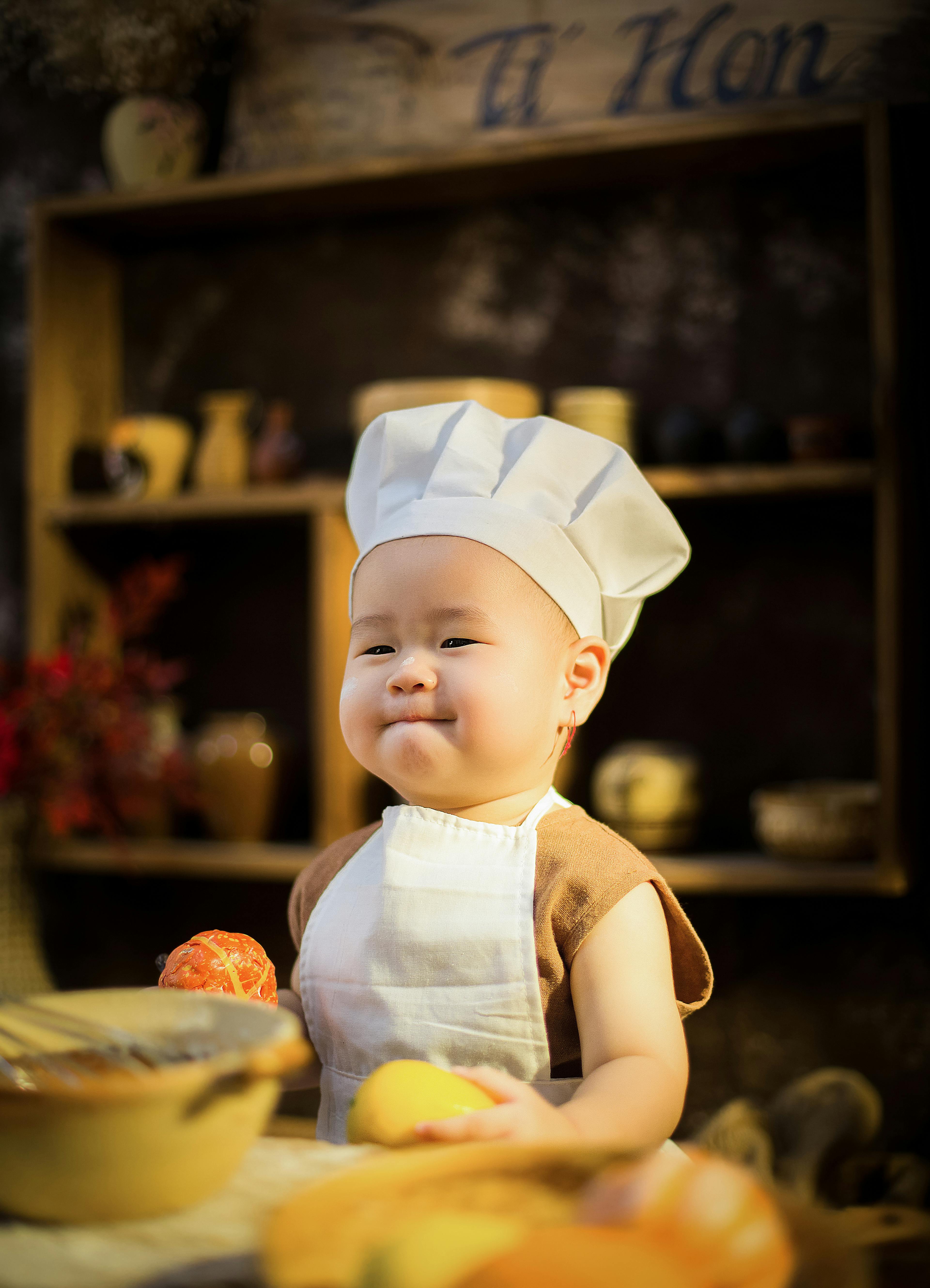Foto gratuita di adorabile, bambino, cappello da cuoco, carino, chef,  costume, cucina, cucinando, cucinare, grembiule, innocenza, piccolo,  ragazzo, sorridente, tiro verticale