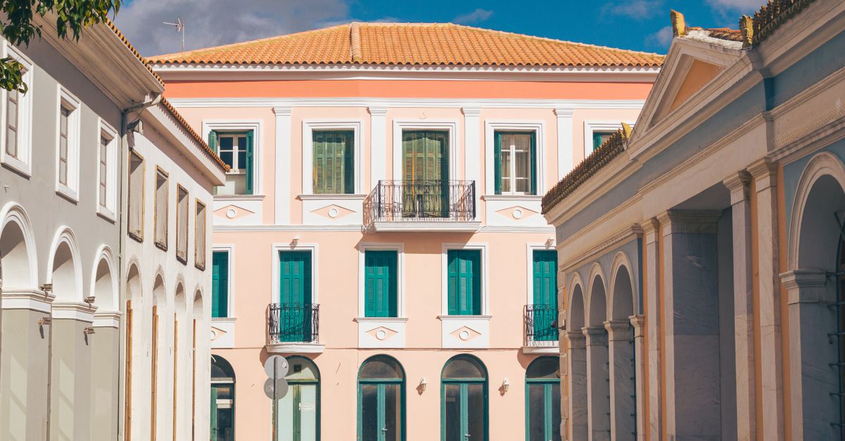 Charming European street view featuring classic architecture, pastel colors, and arched windows under a clear sky.