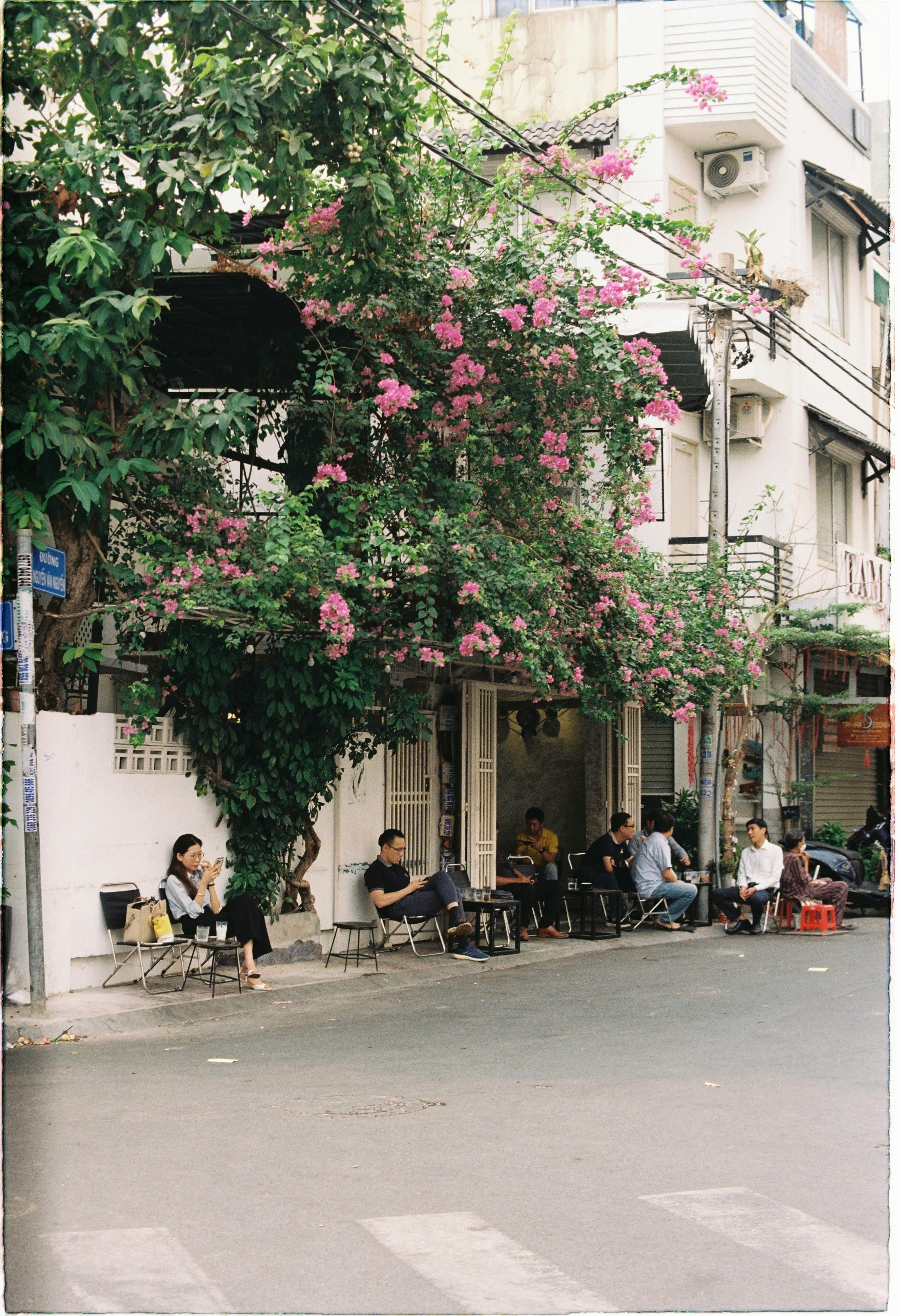Gratis Personas Sentadas Afuera De Un Café En La Acera En Primavera Foto de stock