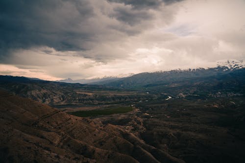 Aerial View of Mountains under a Cloudy Sky 