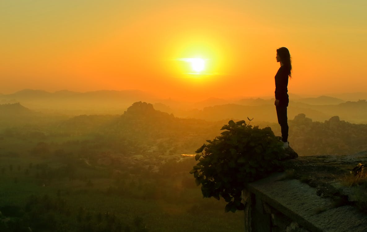 Free Silhouette of Woman Standing Near Cliff Stock Photo