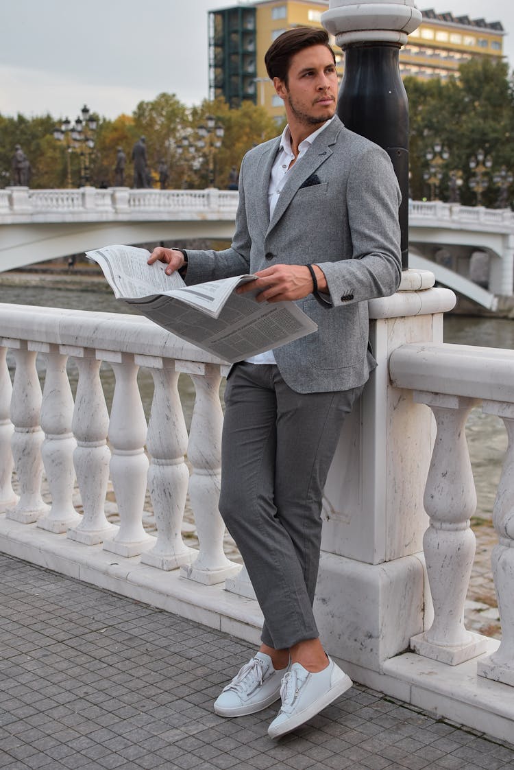 Person Holding Newspaper Wearing Gray Blazer